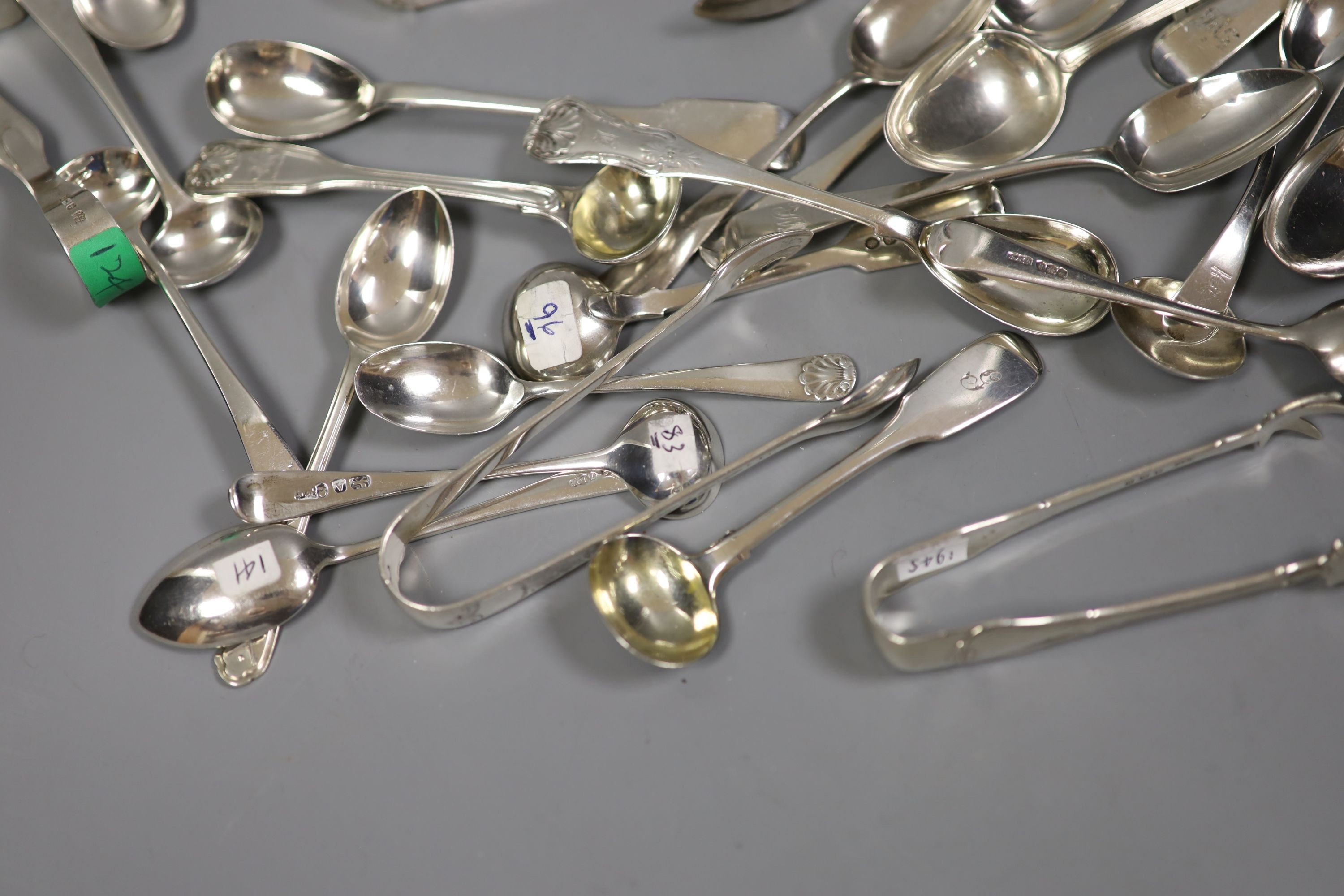 A quantity of assorted silver flatware including Georgian and later sugar tongs, condiment spoons etc.18oz.